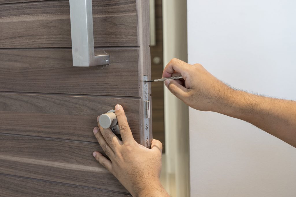 locksmith with screwdriver fix modern wood door